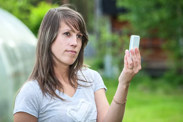 Caucasian woman holding phone up — Stock Photo, Image