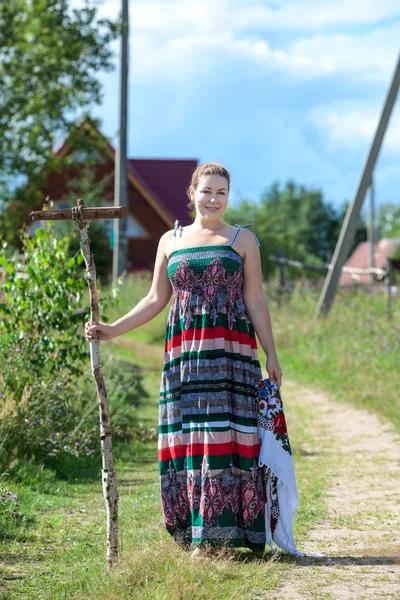Сельская женщина, стоящая с граблями — стоковое фото