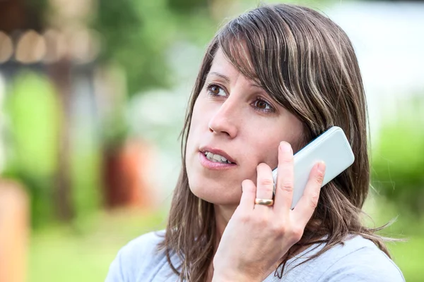 Caucasian young woman talking on the cell phone outdoor — Stock Photo, Image