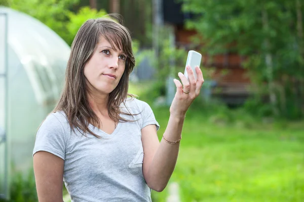 Kaukasierin hält Telefon hoch — Stockfoto