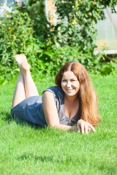 Vrouw liggend op gras — Stockfoto