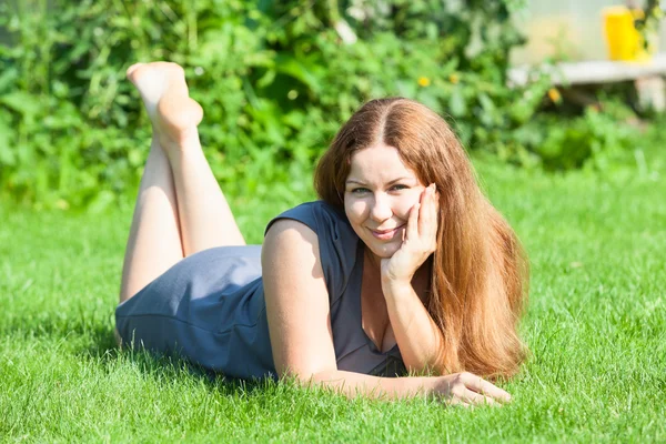 Vrouw liggend op groen gras — Stockfoto