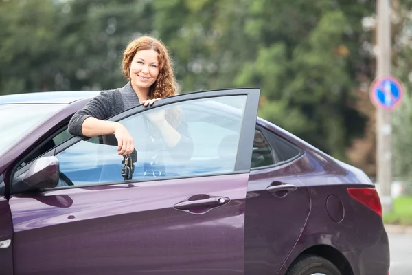 Молодая женщина рядом с собственной машиной — стоковое фото
