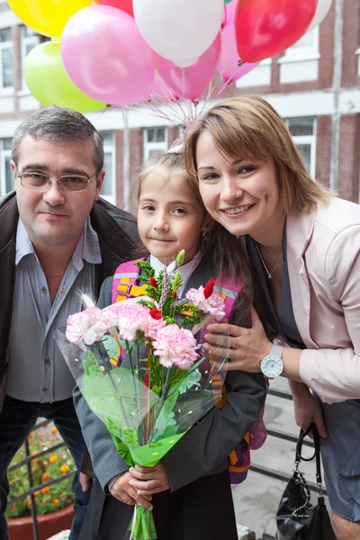 Piccola studentessa con i suoi genitori a scuola — Foto Stock