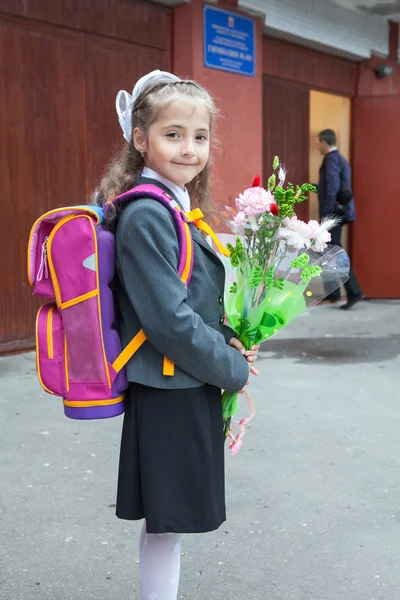 Liten skolflicka stående nära hennes skola — Stockfoto