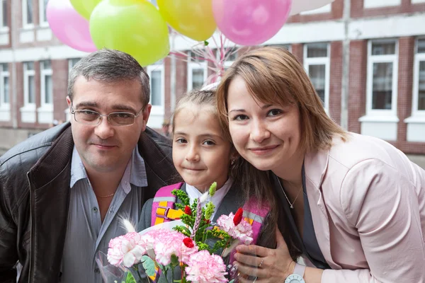 Weinig schoolmeisje met haar ouders op de school — Stockfoto
