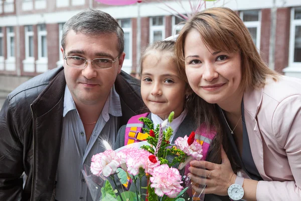 Trochę uczennica z rodzicami w szkole — Zdjęcie stockowe