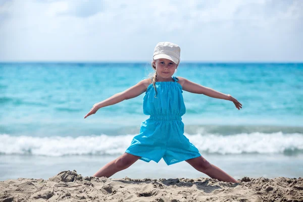 Petite fille pratiquant le yoga à la plage de la mer — Photo