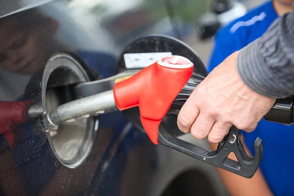 Nahaufnahme der Hand des Fahrers, der an der Tankstelle eine Zapfpistole mit Benzin einsetzt — Stockfoto