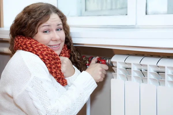 La mujer siente frío al girar el termostato —  Fotos de Stock