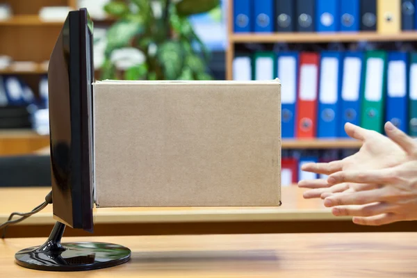Human hands catching carton box from the monitor — Stock Photo, Image