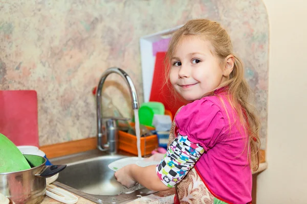 Girl in the kitchen ashing dishes, copyspace — Stock Photo, Image