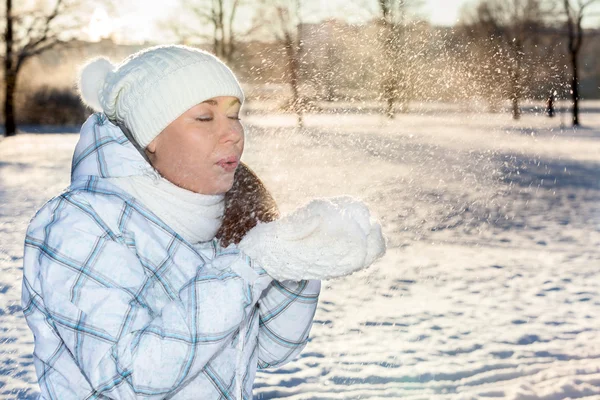 Mujer soplando en la nieve — Foto de Stock