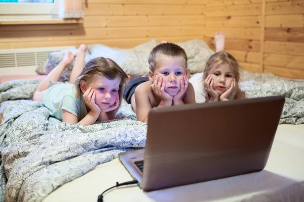 Troje dzieci patrząc na laptopa — Zdjęcie stockowe