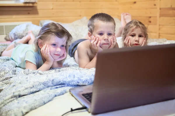 Трое детей смотрят на ноутбук — стоковое фото