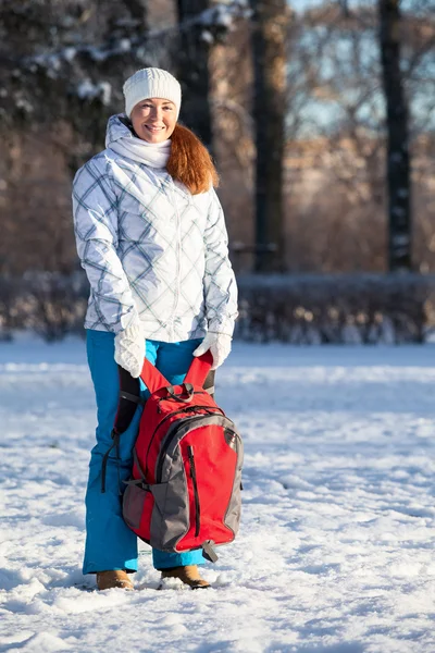 Giovane donna con zaino nel parco invernale — Foto Stock