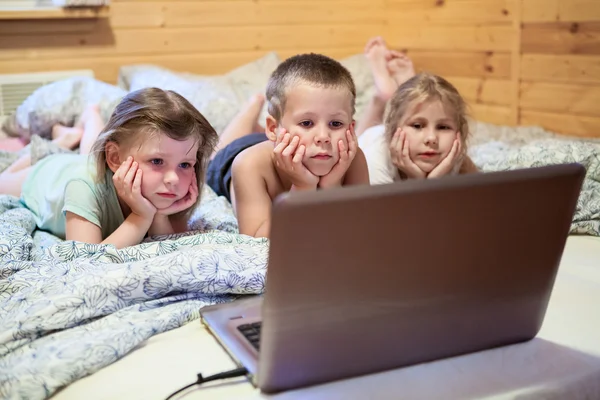 Drei Kinder schauen auf Laptop — Stockfoto