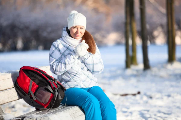 Young woman with backpack in winter park — Stock Photo, Image