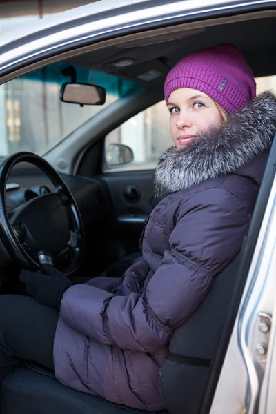 Frau in Winterkleidung sitzt im Auto — Stockfoto