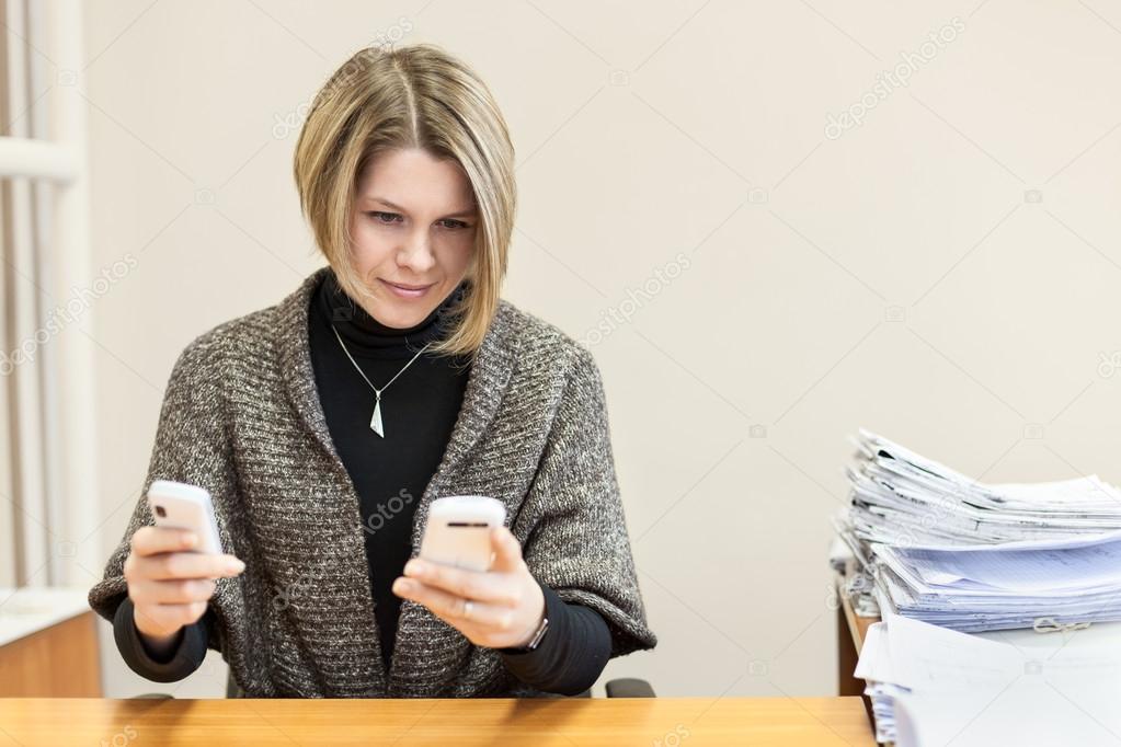 Businesswoman with two smartphones
