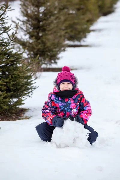 Flicka göra snögubbe — Stockfoto
