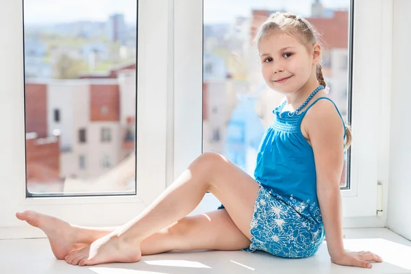 Girl sitting on windowsill — Stockfoto