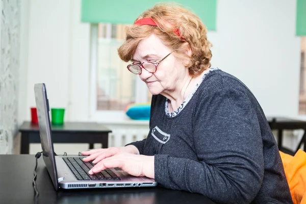 Elder woman typing — Stock Photo, Image