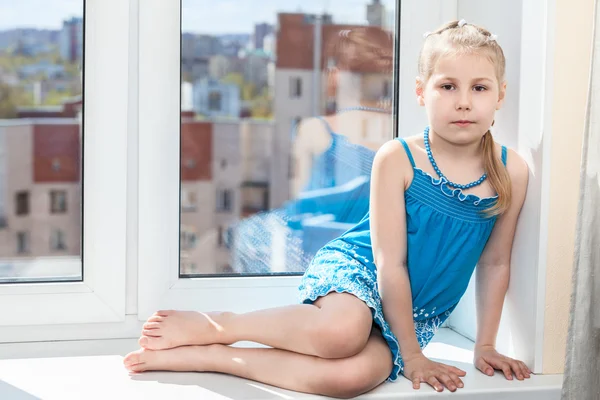 Criança sentada na janela — Fotografia de Stock