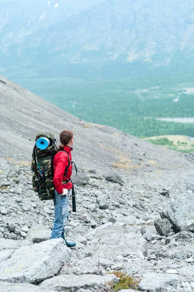 Bergsteiger mit Rucksack in den Bergen auf der Passhöhe — Stockfoto