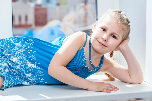 Niña tendida en ventana — Foto de Stock