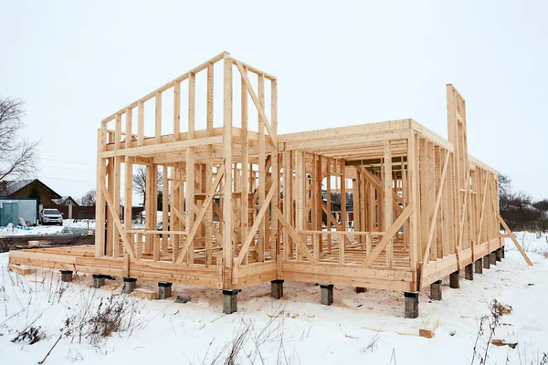 建設中の木造フレームハウス 杭基礎と裸のフレームと壁 冬の季節 — ストック写真