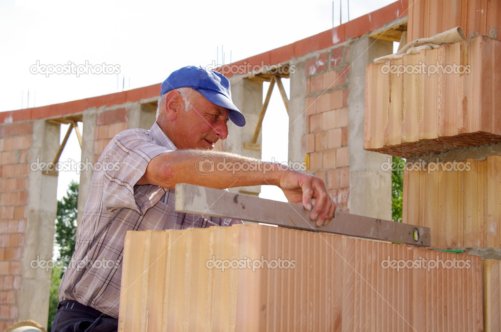 Mature man laying bricks
