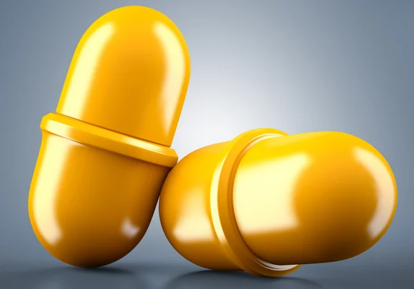 Two golden pills — Stock Photo, Image