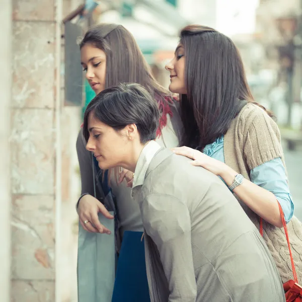 Mujeres jóvenes frente a una tienda de ropa — Foto de Stock