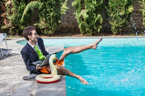 Grappige jonge zakenman met zwembroek naast het zwembad — Stockfoto