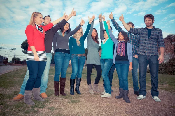 Estudiantes universitarios con pulgares arriba — Foto de Stock
