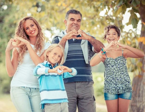 Família feliz com as mãos em forma de coração — Fotografia de Stock