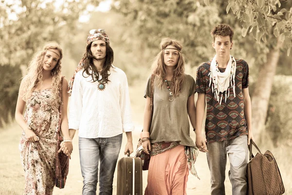 Grupo Hippie Caminhando em uma estrada do campo — Fotografia de Stock