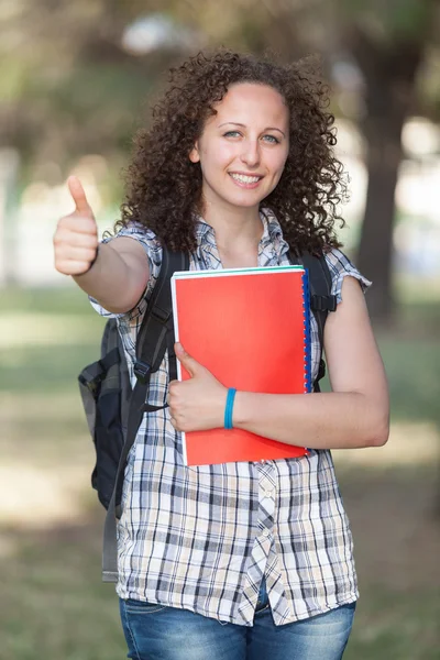 Junge schöne Studentin mit erhobenem Daumen — Stockfoto