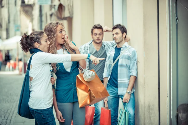 Chicas felices con chicos aburridos en las compras — Foto de Stock