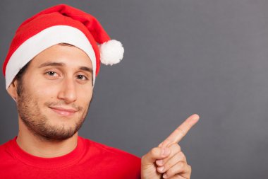 Noel Baba şapkası kopya alanı işaret eden genç adam