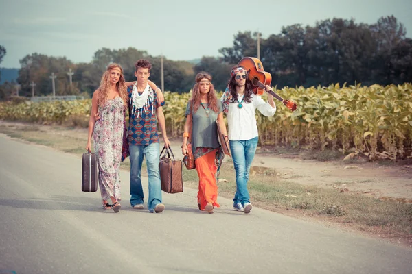 Hippie gruppen gå på en väg som landsbygden — Stockfoto