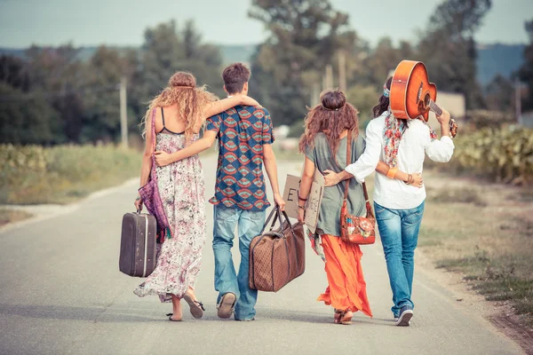 Gruppo Hippie a piedi su una strada di campagna — Foto Stock