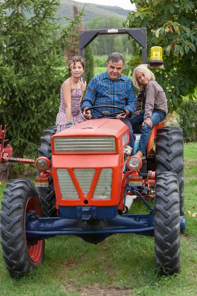 Agricultor adulto con niños en tractor — Foto de Stock