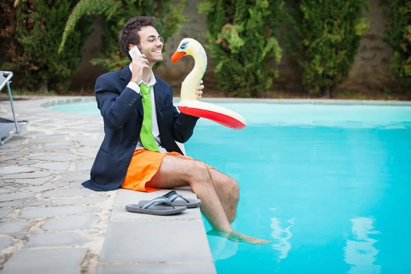 Забавный молодой бизнесмен с плавками рядом с бассейном — стоковое фото