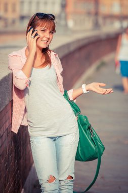 Güzel genç bayan cep telefonuyla konuşuyor.