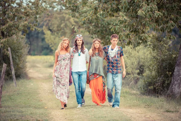 Grupo Hippie Caminhando em uma estrada do campo — Fotografia de Stock