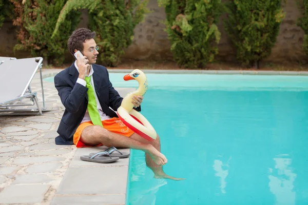 Lustiger junger Geschäftsmann mit Badehose am Pool — Stockfoto