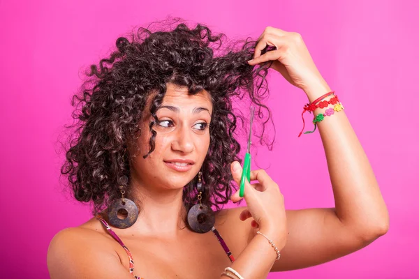 Mujer joven cortando sus cabellos rizados —  Fotos de Stock