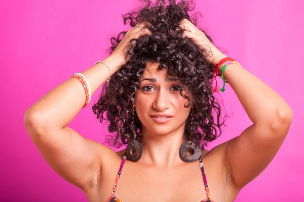 Mujer joven cortando sus cabellos rizados — Foto de Stock